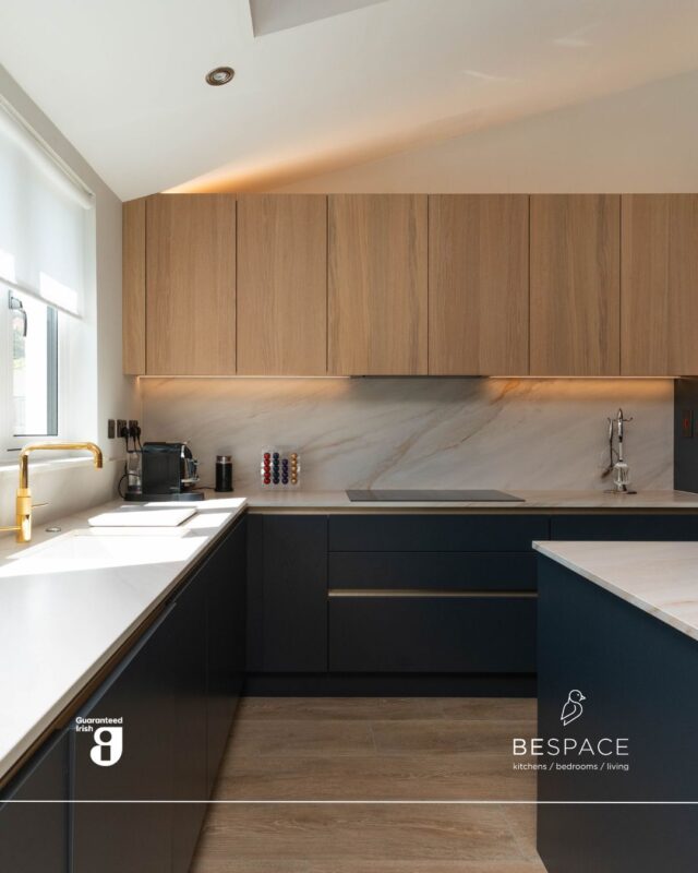 Everyday luxury 💙 

This kitchen blends a deep navy with warm oak tones and Fusion White porcelain worktops for a timeless, layered look. Gold handles and a matching tap add a subtle touch of luxury that pulls everything together 🤝

The island includes seating, built-in storage and a wine cooler, while a dedicated drinks press adds extra hidden workspace to keep everything effortlessly organised.

Book a consultation or visit our showrooms today | Link in bio
